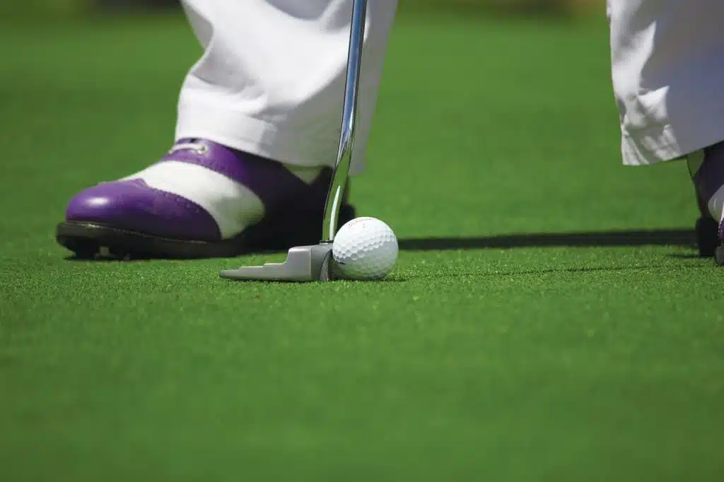 man putting on indoor putting green