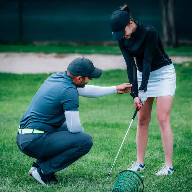 Learning golf. Golf instructor with young women on a golf course