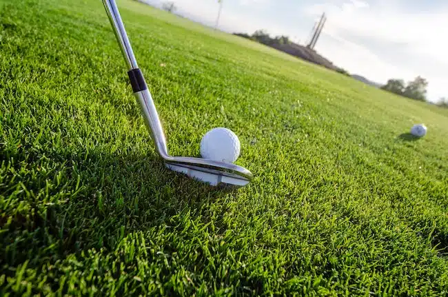iron about to hit golf course on fairway
