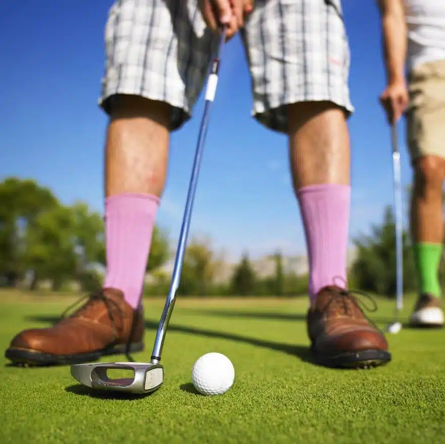 close up man putting with purple socks