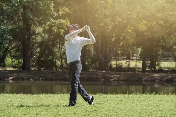 A golfer is driving golf in a golf court.