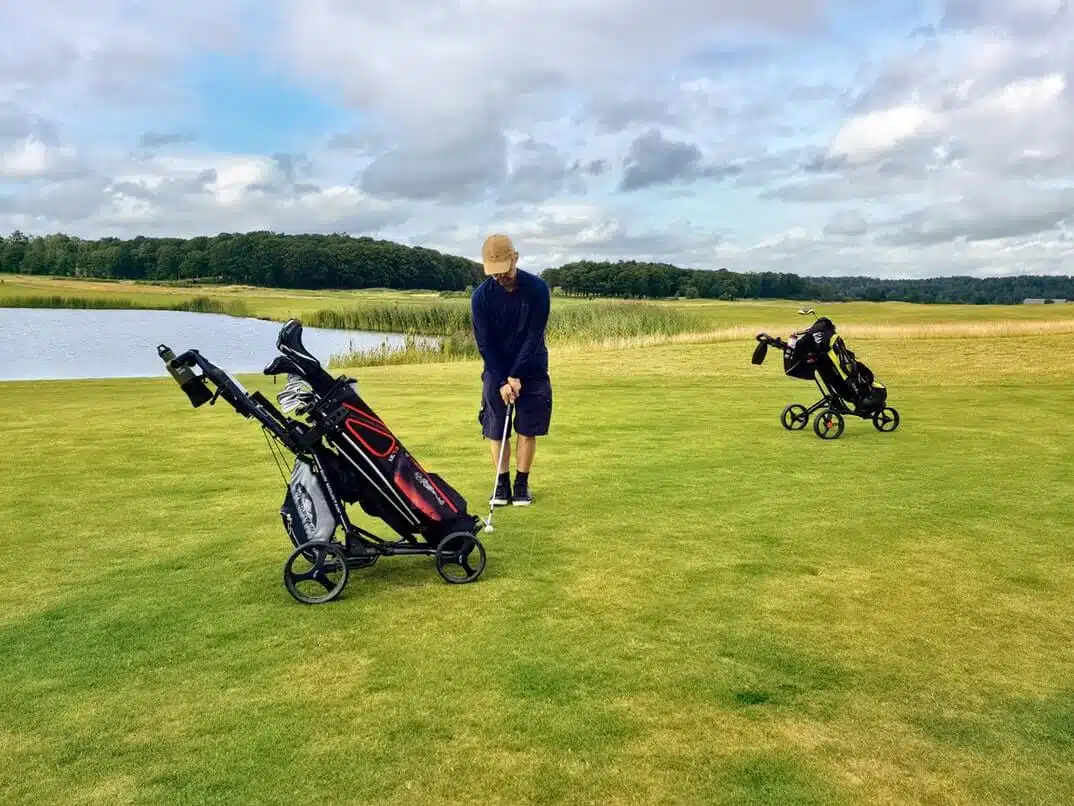 man chipping on golf course