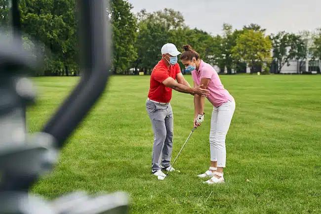 Female player taking a shoulder alignment lesson