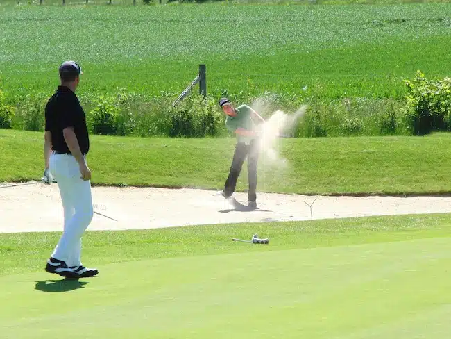 four ball golf man shooting from bunker