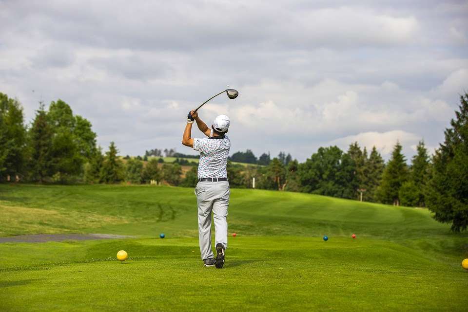 Man hitting a drive on a golf course