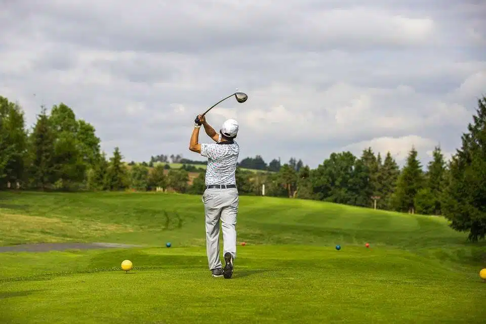 Man hitting a drive on a golf course