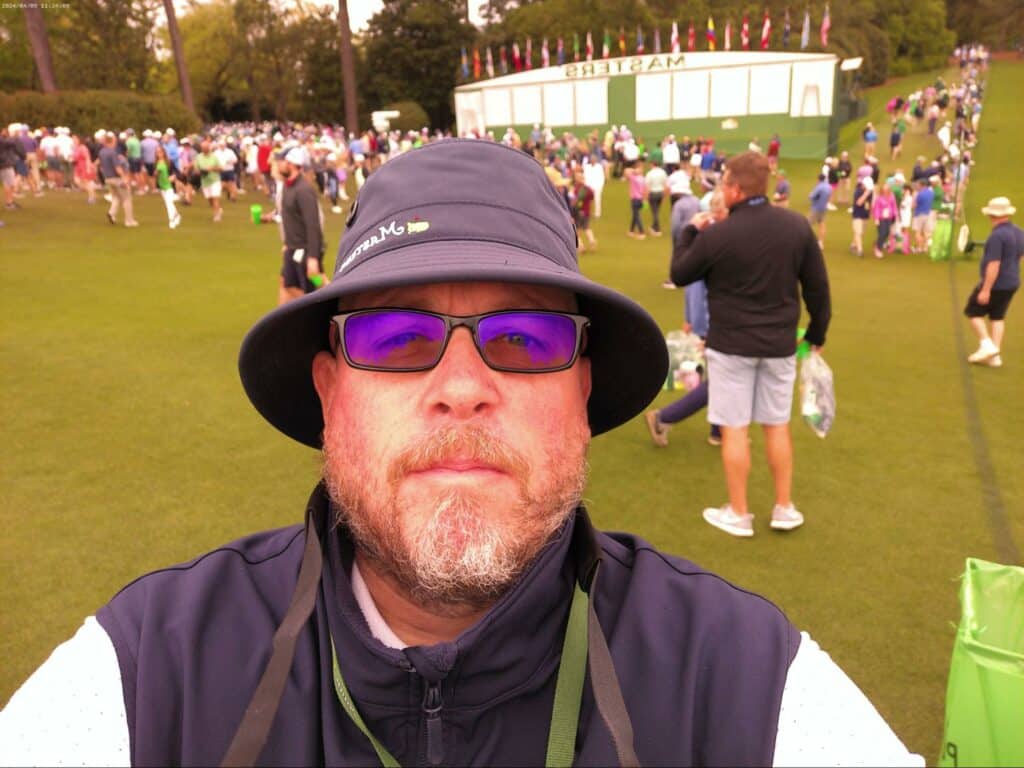 Brendon Elliott at Masters 2024 in front of the scoreboard