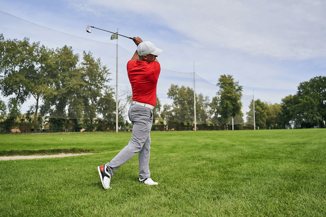 Fit-man-swinging-his-wedge-golf-club-outdoors-2021-09-03-14-18-23-utc