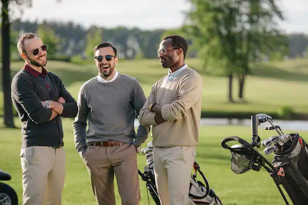 happy multiethnic golfers spending time together in golf course