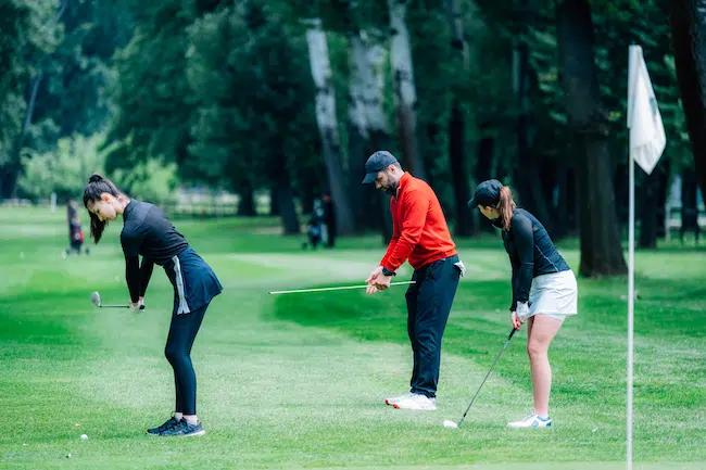 Two-young-golfers-practicing-chipping-shots-on-a-g-2021-08-28-23-18-31-utc