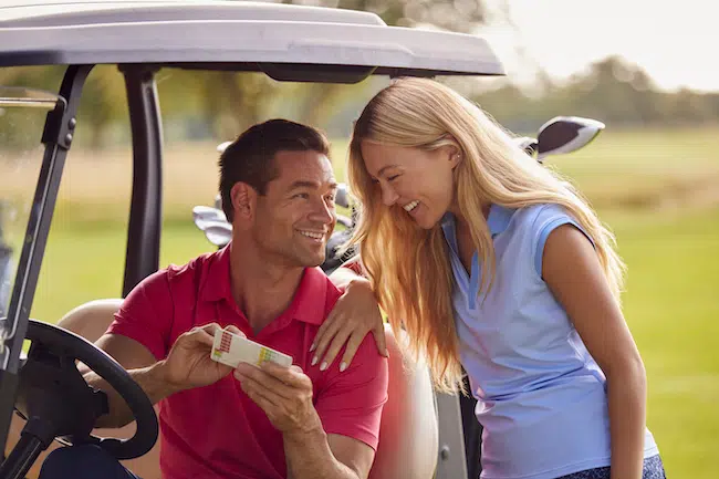 Couple-sitting-in-buggy-playing-round-on-golf-toge-2021-12-09-15-26-00-utc