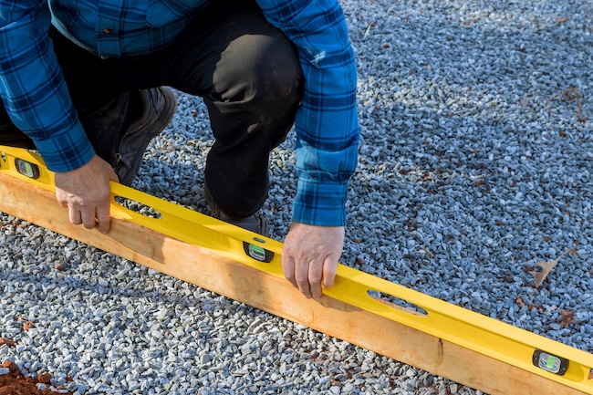 Building a level surface on which to place gravel for the foundation of the shed in the backyard.