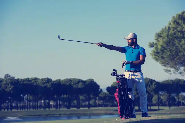 handsome middle eastern golf player portrait at course at sunny day