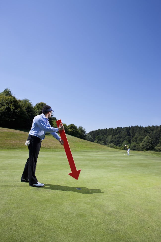 Caddy pointing at a hole on golf course