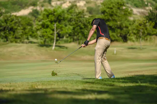 man hitting golf ball