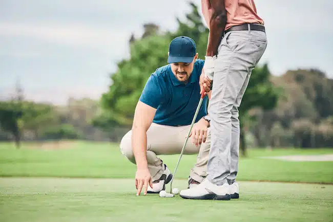 Teaching, golf lesson and sports coach help man with swing, putter and stroke outdoor. Golfing, gre