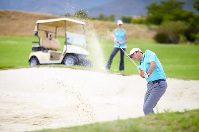 golfer hitting out of bunker