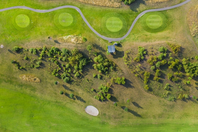 Aerial view of golf course. Drone or helicopter view of green field sand bunker