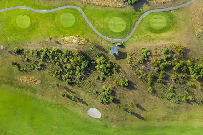 Aerial view of golf course. Drone or helicopter view of green field sand bunker