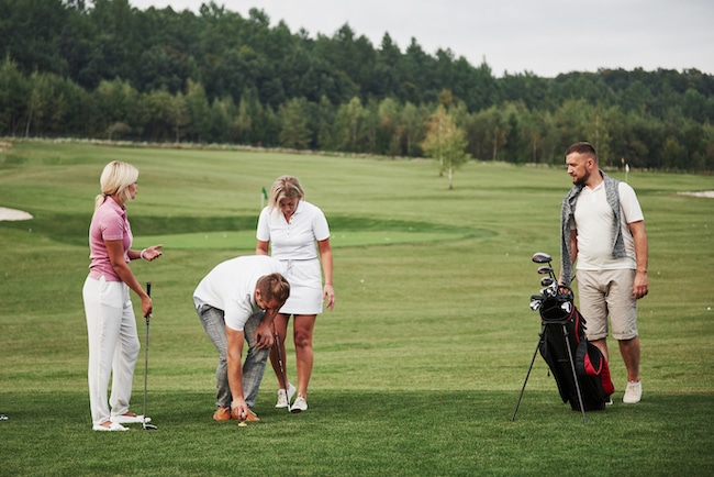 Group of stylish friends on the golf course learn to play a new game