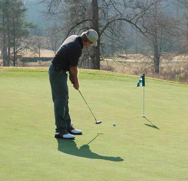 golf drinking game man putting on green golf course