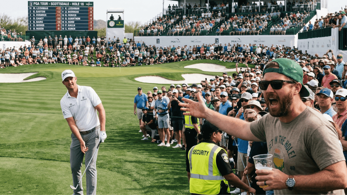 A crowded golf tournament with a rowdy fan in the foreground yelling